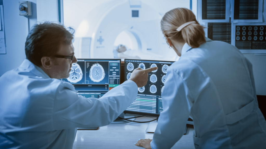two doctors looking at ct scan images and discussing the results
