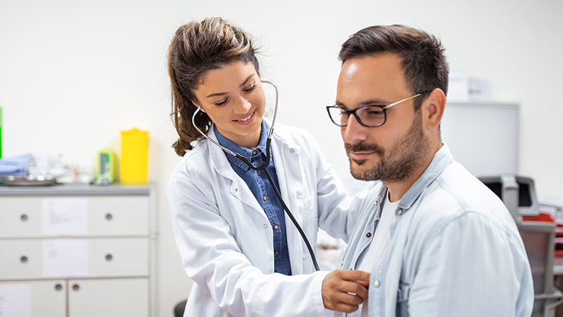 Young doctor is using a stethoscope listen to the heartbeat of the patient. Shot of a female doctor giving a male patient a check up